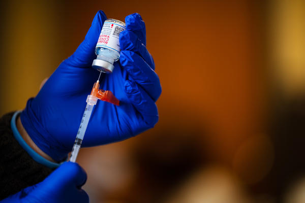 A medical technician fills a syringe from a vial of the Moderna COVID-19 vaccine earlier this year.