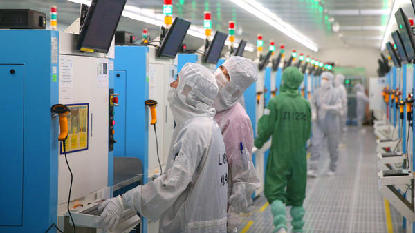 The Senate is expected to approve incentives for U.S. companies to compete with China on technology. Here, employees work this week at a Chinese factory producing silicon wafers.
