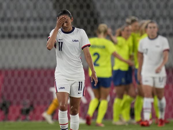 U.S. player Christen Press reacts as Sweden's players celebrate their third goal during a women's soccer match at the Olympics on Wednesday in Tokyo.
