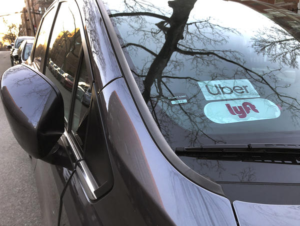 Uber and Lyft sign in windshield of car, Queens, New York.