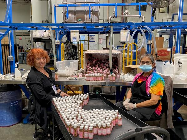 Alice Gomez and Maria Ramos work at Dr. Bronner's soap factory in Vista, Calif. The company is doing weekly coronavirus testing but still wants all its workers vaccinated.