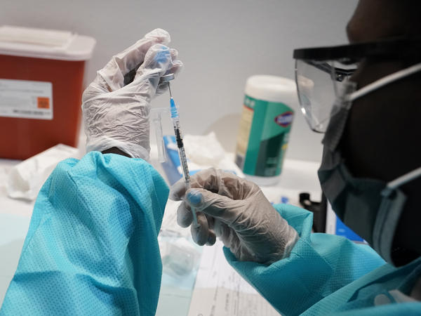 A health care worker fills a syringe with the Pfizer-BioNTech COVID-19 vaccine at the American Museum of Natural History in New York City this year.