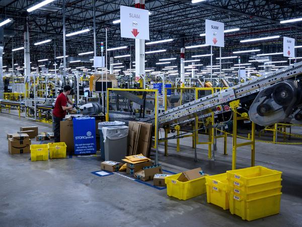 A man works at a conveyor belt at an Amazon warehouse in New York City in 2019.