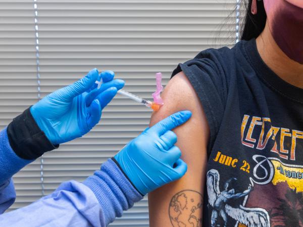 A health care worker administers a COVID-19 vaccine to a resident at the Jordan Valley Community Health Center in Springfield, Mo., in June.