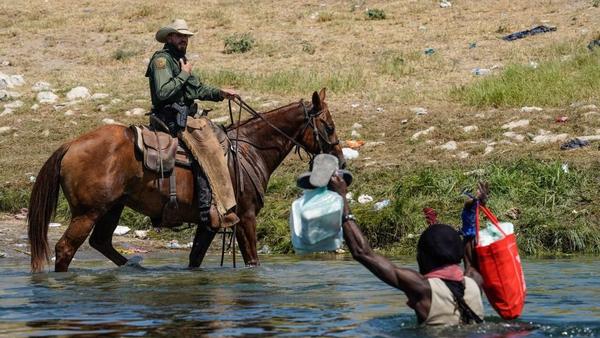 A U.S. Border Patrol agent on horseback tries to stop a Haitian migrant from entering an encampment on the banks of the Rio Grande in Del Rio, Texas. The Department of Homeland Security has pledged an investigation into the matter.