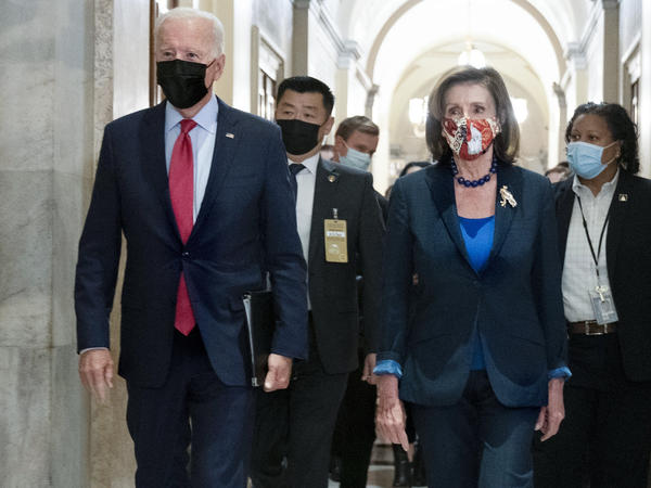 President Biden walks with House Speaker Nancy Pelosi, D-Calif., as he arrives Friday for a meeting with House Democrats to discuss their spending agenda.