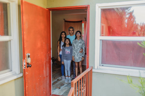 Nitin Bajaj and Nimisha Lotia stand with their kids inside the empty and damaged apartment unit earlier this month in Los Angeles. The former tenants had lived there for months without paying rent.