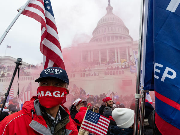 A protester unleashes a smoke grenade in front of the U.S. Capitol building on Jan. 6.