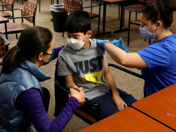 Ari Blank got a comforting hand-squeeze from his mom in May as he was vaccinated against COVID-19 in Bloomfield Hills, Mich. This week, the Food and Drug Administration authorized the use of Pfizer's vaccine in even younger kids — ages 5 to 11.