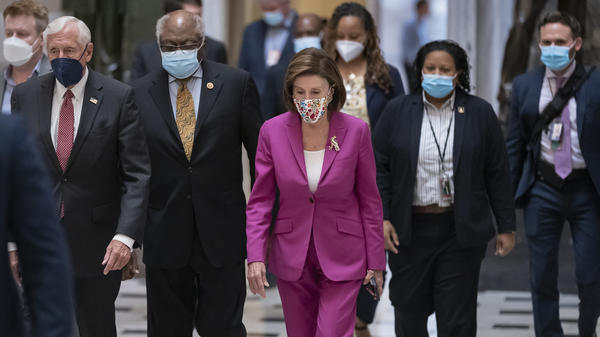 House Speaker Nancy Pelosi, D-Calif., joined on the left by House Majority Leader Steny Hoyer, D-Md., and House Majority Whip James Clyburn, D-S.C., walks to update reporters about spending negotiations at the Capitol on Friday.