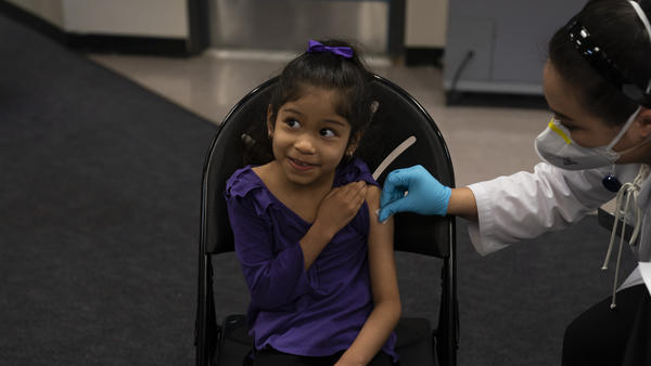 Elsa Estrada, 6, smiles at her mother before receiving the Pfizer-BioNTech COVID-19 vaccine on Tuesday at a pediatric vaccine clinic for children at Willard Intermediate School in Santa Ana, Calif.