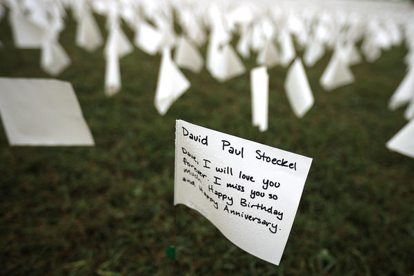 A personal message to a person who died of COVID-19 is written on a small flag that is part of 'In America: Remember,' a public art installation commemorating all the Americans who have died of the coronavirus near the Washington Monument on Sept. 17 in Washington, D.C.