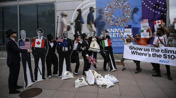 Activists dressed as debt collectors hold cutouts of the leaders of the United States, Canada, Australia, the UK and Italy in front of the International Monetary Fund headquarters in Washington, D.C., last month to ask rich nations to keep their financial commitment to developing countries to tackle climate change.