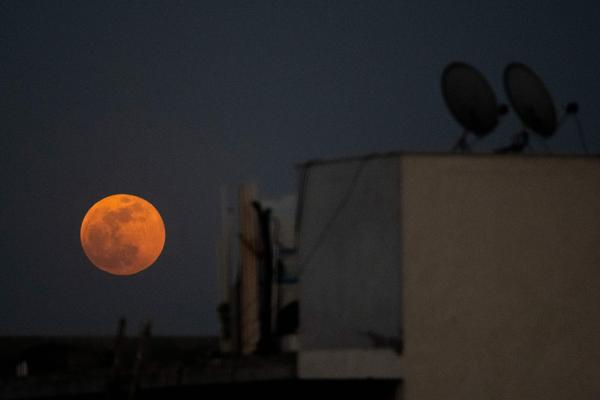 The super blood moon rises over a residential area in New Delhi during a total lunar eclipse in May.