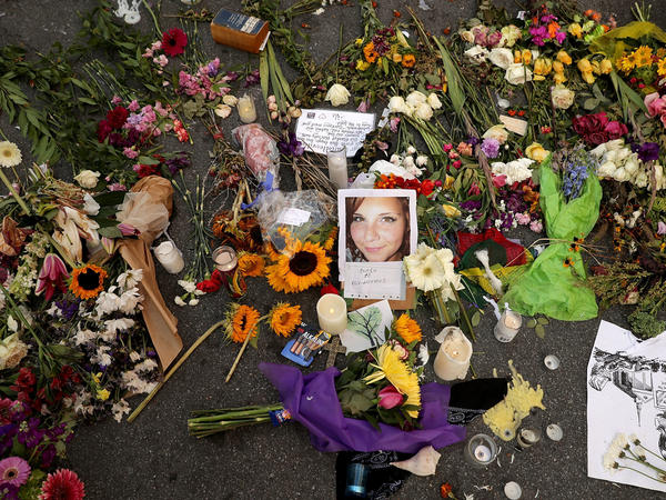 Flowers and candles surround a photograph of Heather Heyer on the spot where she was killed and 19 others injured when a car slammed into a crowd of people protesting against a white supremacist rally in August 2017 in Charlottesville, Virginia.