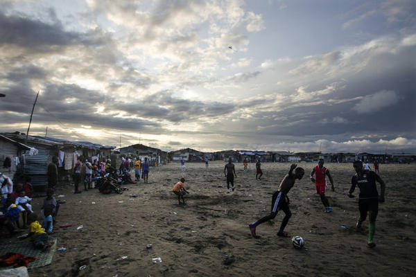 Thanksgiving is a day at the beach — quite literally — for young Liberians. Above, the beach in West Point is a sandy playing field for soccer lovers.