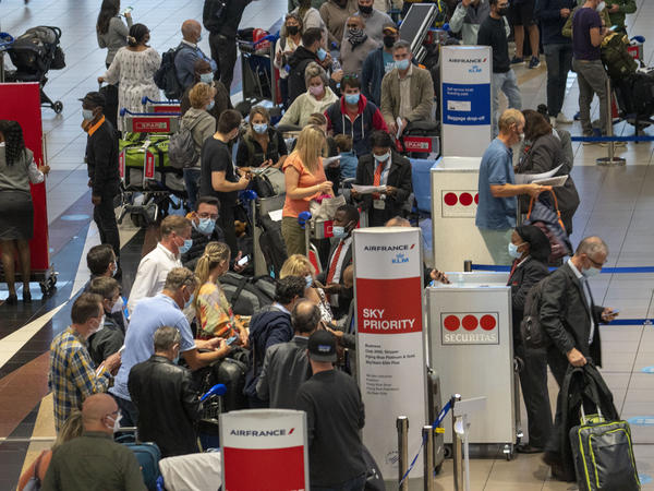 People line up to get on an Air France flight to Paris at OR Tambo's airport in Johannesburg, South Africa, on Friday as several countries announced travel bans in response to the omicron variant of the coronavirus.