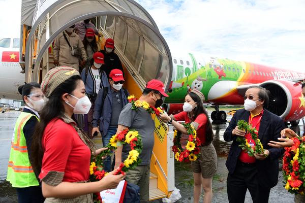 Arriving South Korean tourists receive flower garlands at Phu Quoc international airport on November 20, 2021, as the island welcomes its first international tourists to arrive after a Covid-19 coronavirus vaccine passport scheme kicked off this month in Vietnam.