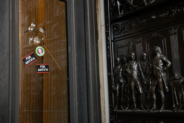 Stickers reading "Fck Antifa" are stuck on a broken window at the U.S. Capitol after the building was breached by rioters on Jan. 6.