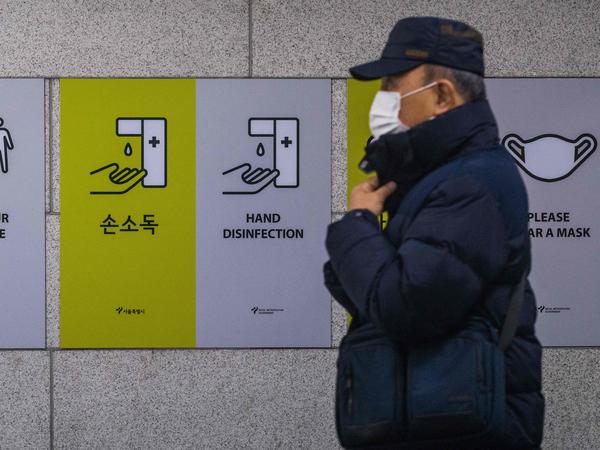 A commuter walks past information boards displayed to remind the public about how to help prevent the spread of the coronavirus in Seoul on Wednesday.