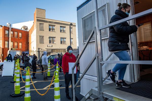 People line up to get tested for COVID-19 at East Boston Neighborhood Health Center in Boston, Mass., on Monday.