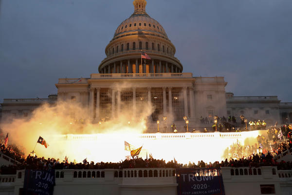 An explosion caused by a police munition is seen while supporters of then-President Donald Trump gather in front of the U.S. Capitol in Washington, D.C., on Jan. 6.