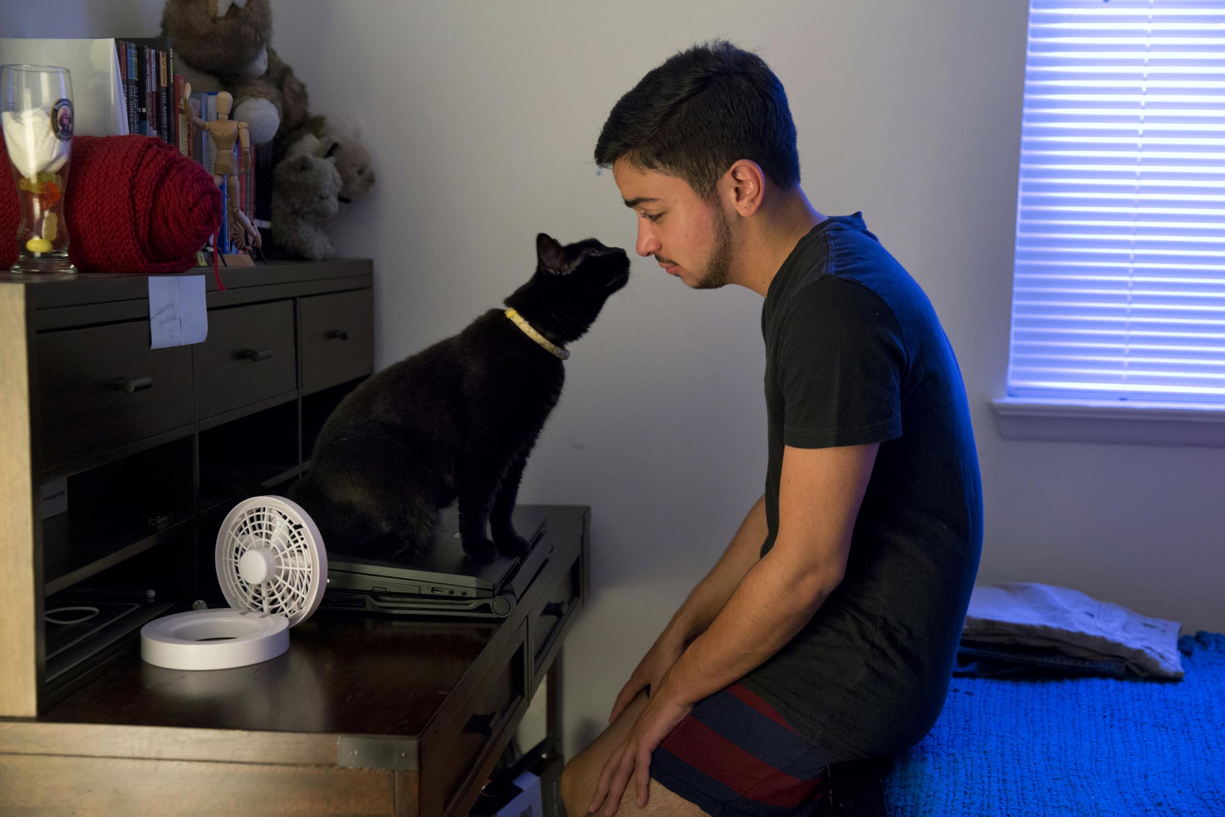 younes relaxes in the morning with one of his cats, beans, at