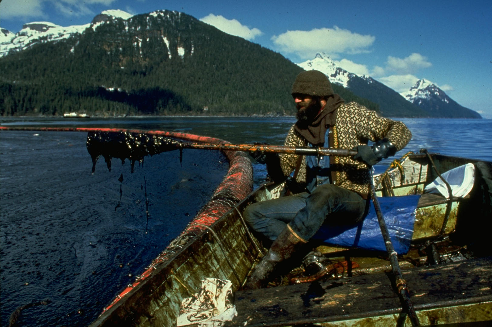 A cleanup worker lifts an oar near a boom in Prince William Sound, Alaska, ...