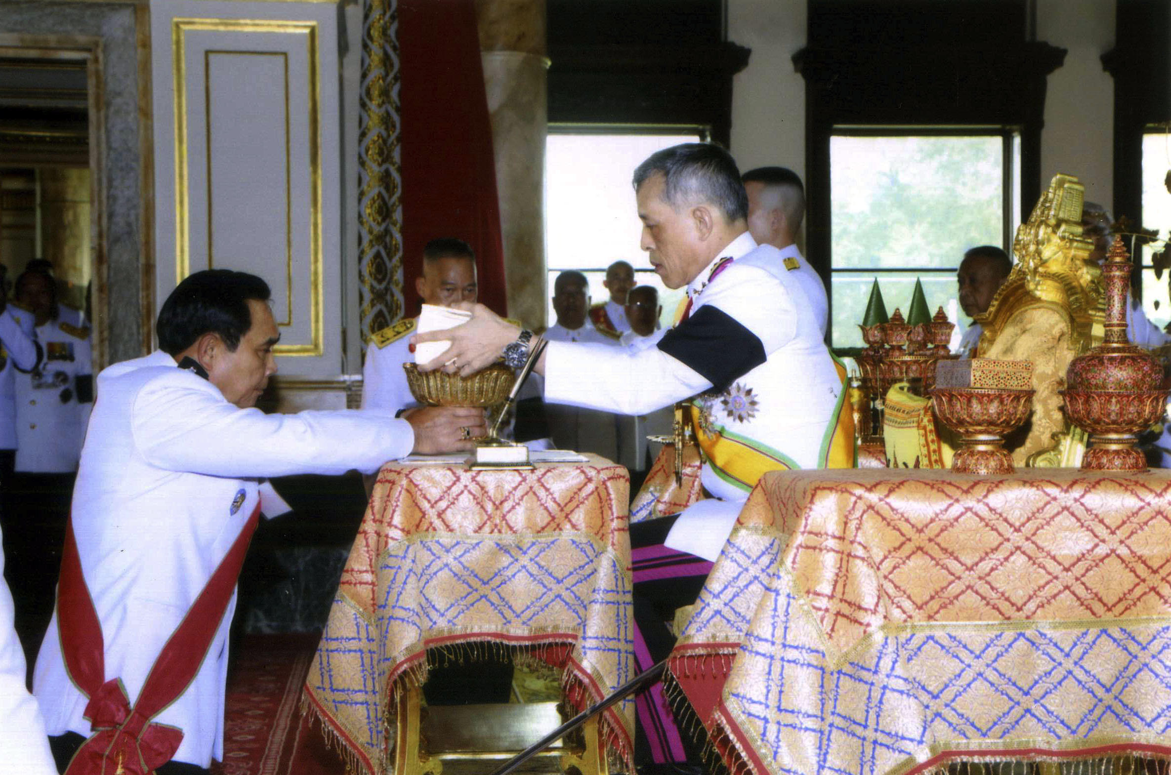 El Rey Vajiralongkorn Bodindradebayavarangkun (derecha) firma la nueva constitución de la junta durante la ceremonia junto al Primer Ministro y líder de la junta Prayuth Chan-ocha (izquierda) | Fuente: Associated Press