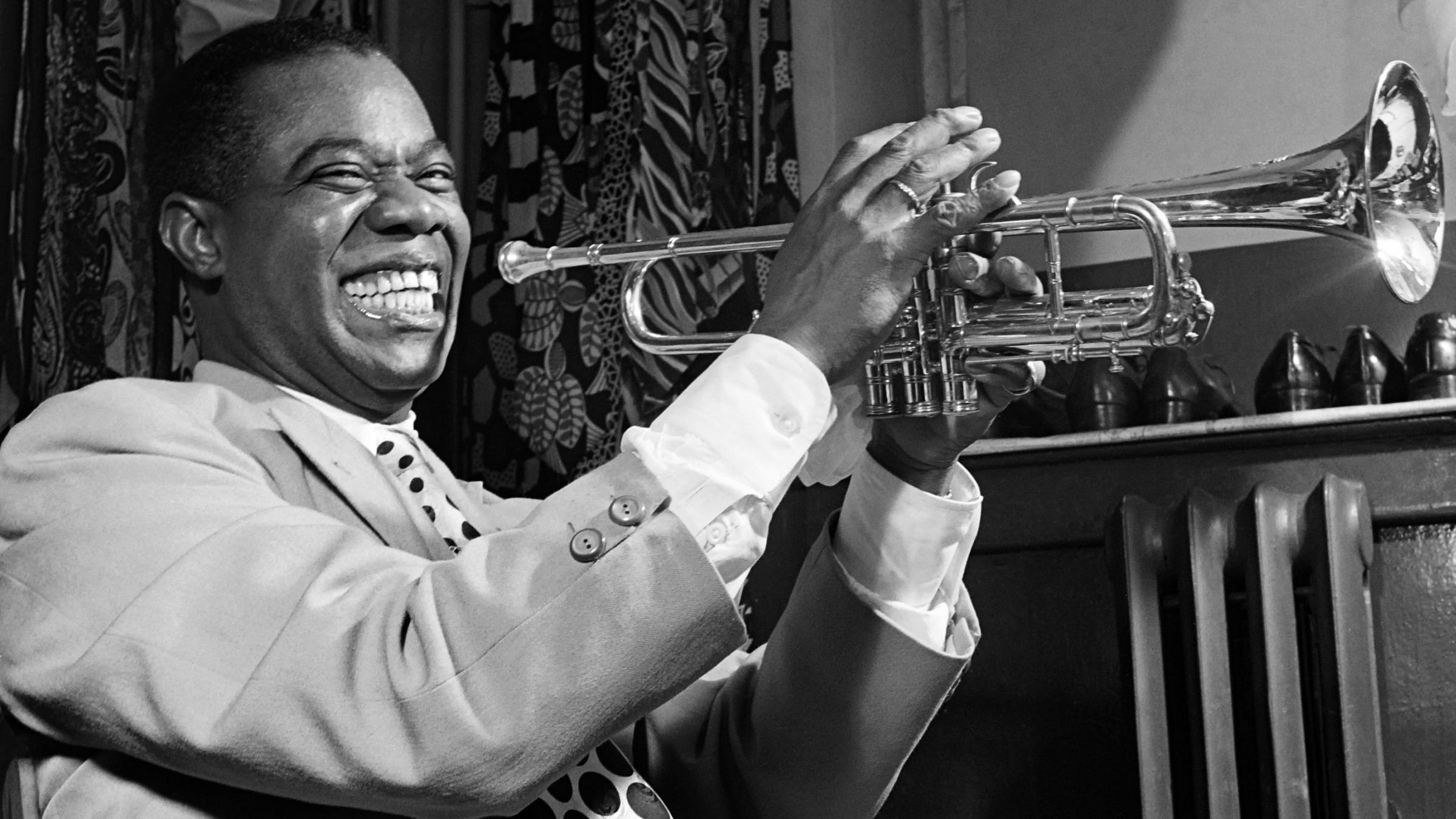 March 1950: Louis Armstrong plays trumpet in his dressing room before a show in New York.