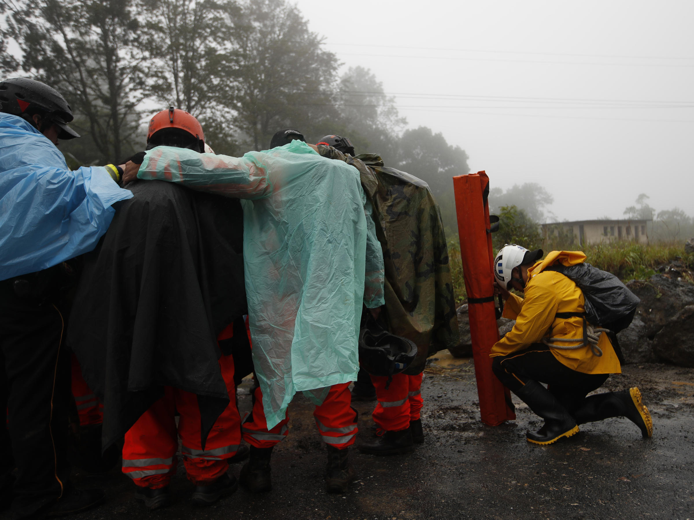 Volunteer firefighters huddle in prayer before beginning a search and rescue operation Nov. 7 in San Cristóbal Verapaz Guatemala in the aftermath of Hurricane Eta