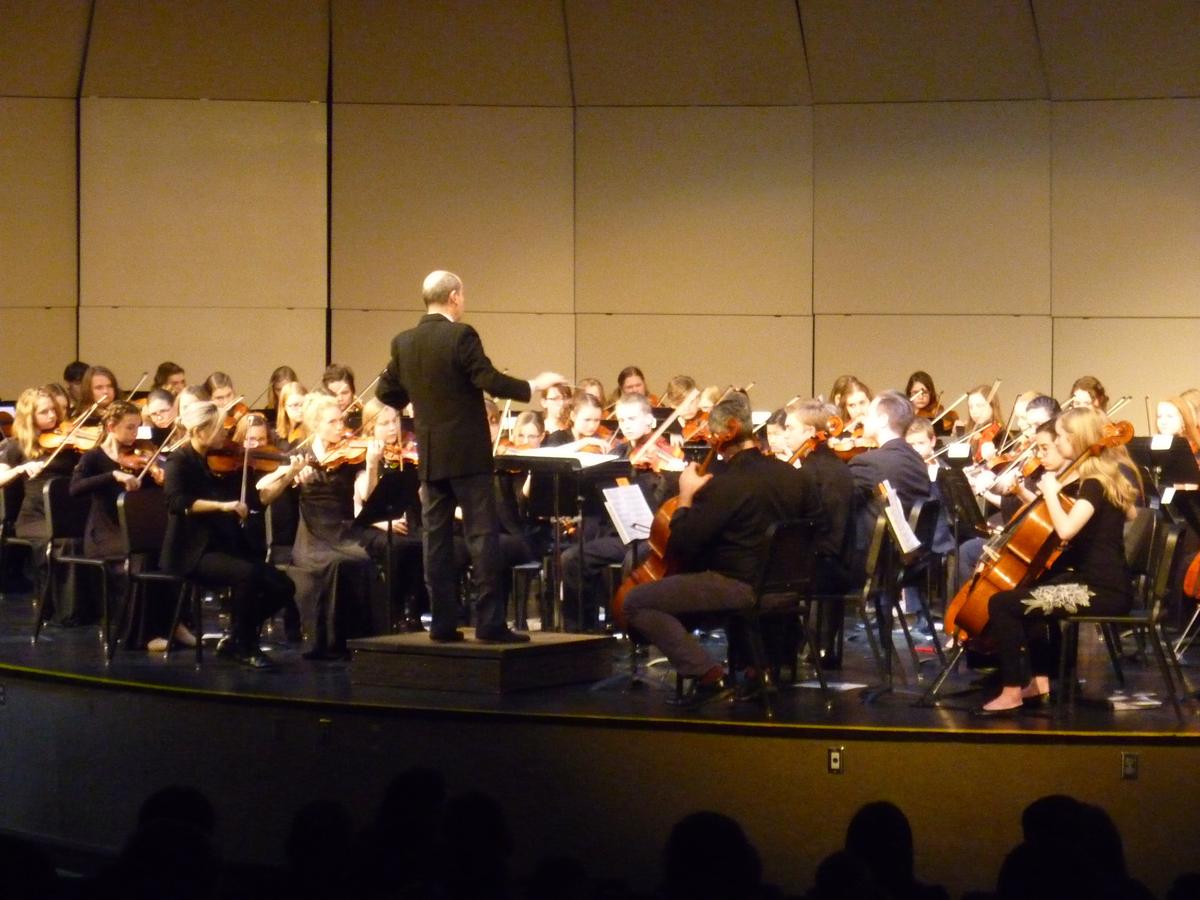 high school orchestra students perform concert with professional