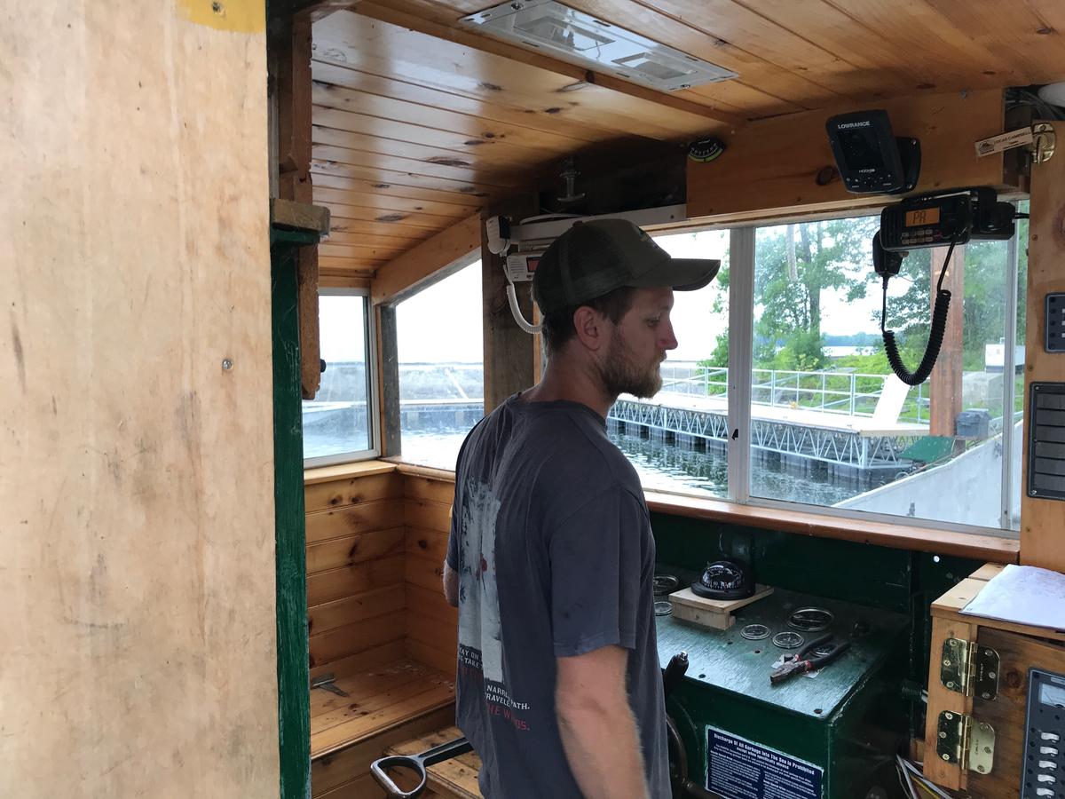 Lucas Campbell stands in the wheelhouse of his landing craft. (Henry Epp/VPR)