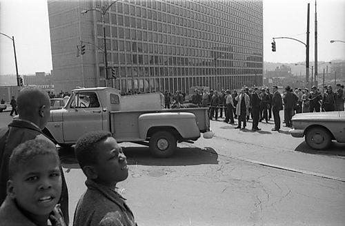 People stand near Washington Plaza watching the armed police officers form a barricade across Centre Avenue on April 7, 1968. (Charles R. Martin Photographs/University of Pittsburgh)