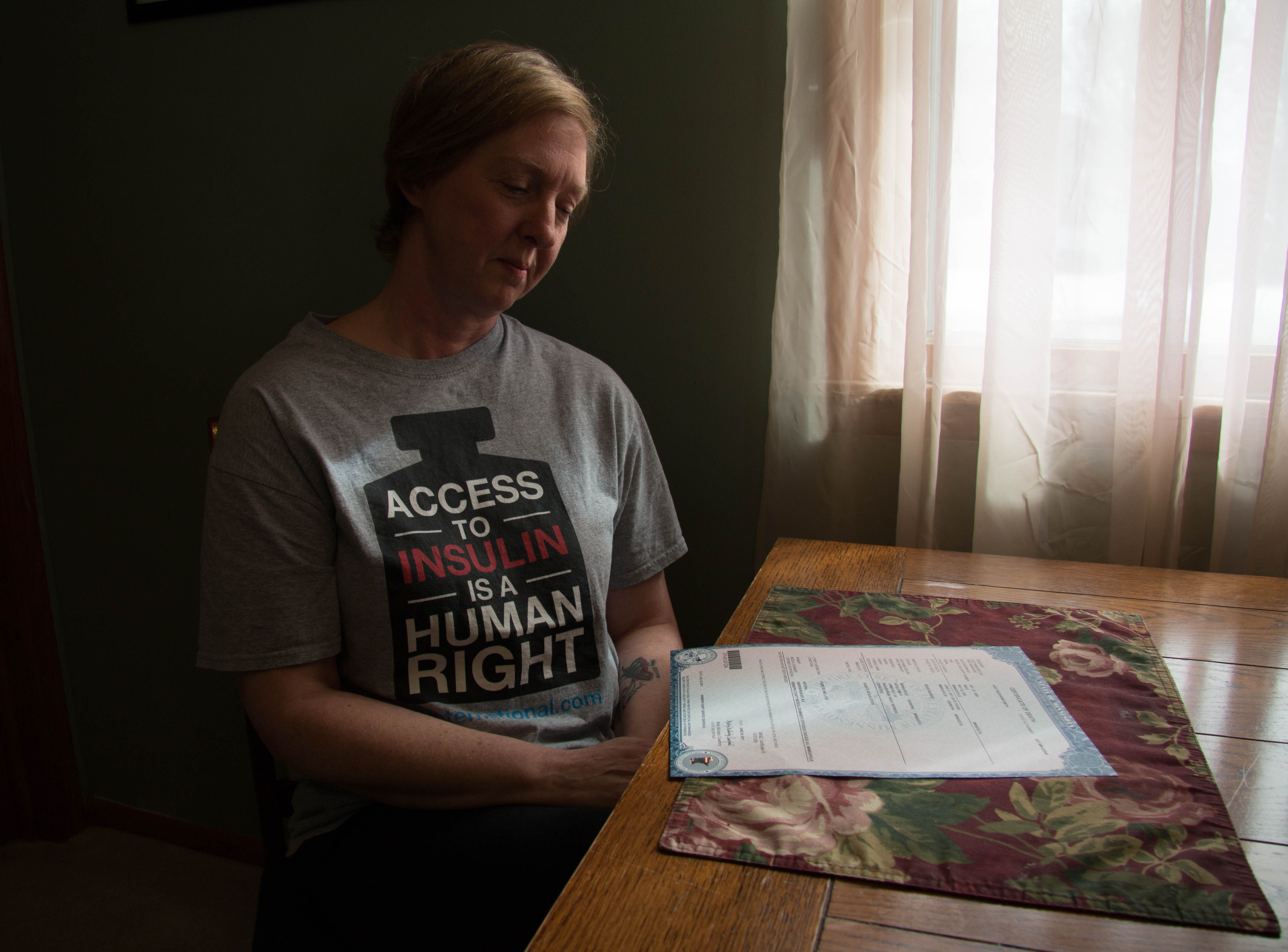 Nicole Smith-Holt looks at her son Alec's death certificate in her Richfield, Minn. home. Alec died in 2017 from diabetic ketoacidosis. 