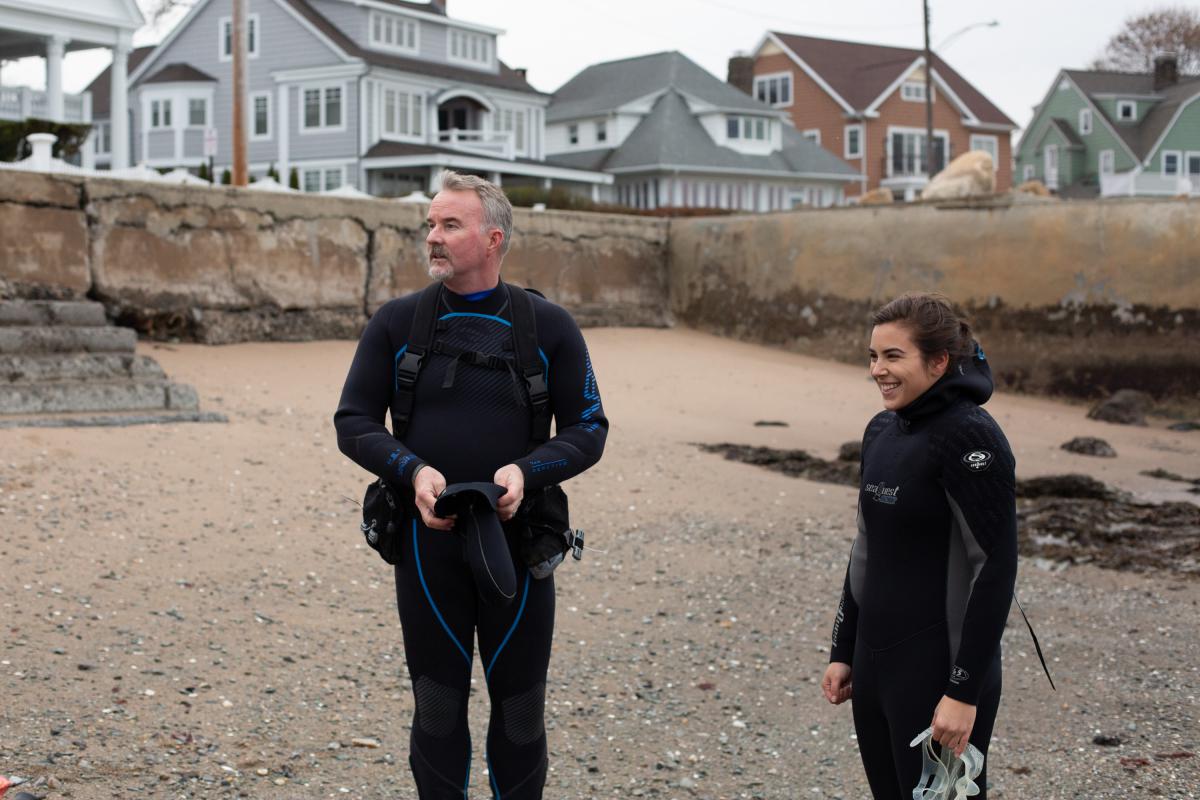 Sean Grace (left) and diver Gabriella DiPreta get ready to enter the water in Milford, Conn., on Friday, Nov. 22. (Patrick Skahill/Connecticut Public Radio)
