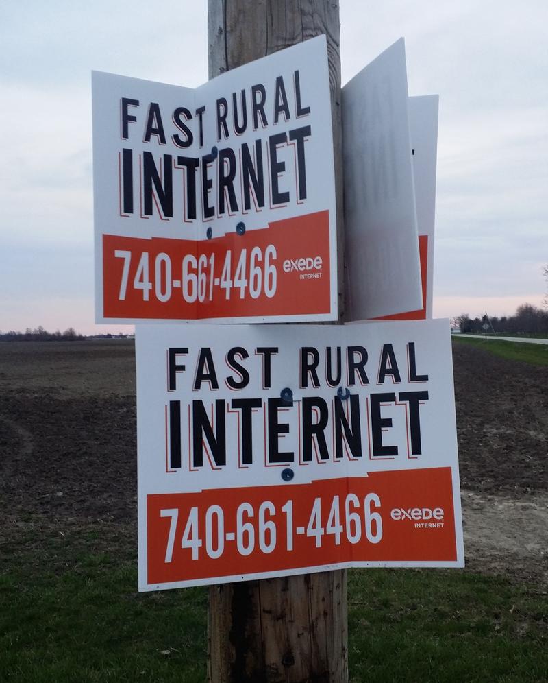 Signs in rural Fayette County advertise satellite-to-home internet service