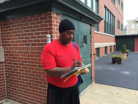 AIDS Care Ocean State outreach worker Keith Thompson completes some paperwork at a stop in Woonsocket.